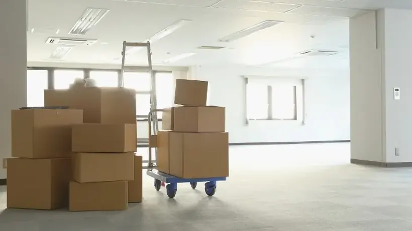 Cajas y carretilla en un espacio común antes de su retirada