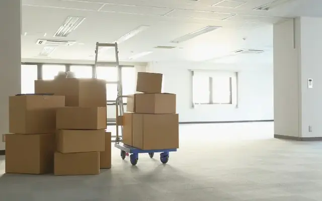 Cajas y carretilla en un espacio común antes de su retirada